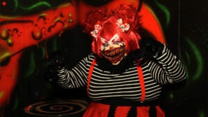 A woman in a Halloween red outfit with creepy make-up.